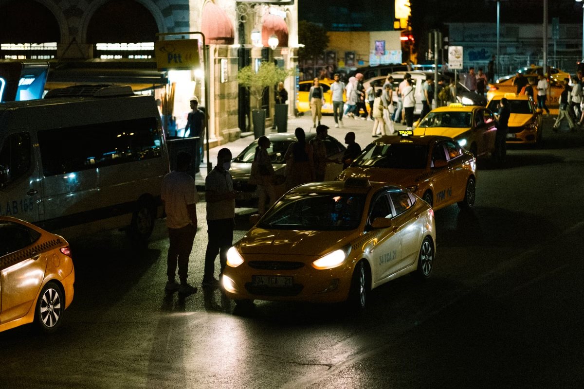 Reizigers stappen ’s avonds in bij een rij taxi’s